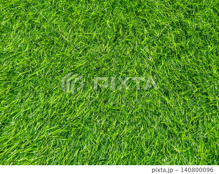 Vibrant Green Artificial Grass Texture  Lush Synthetic Turf Background outdoor landscaping, sports field backgrounds, and modern floor coverings. 140800096