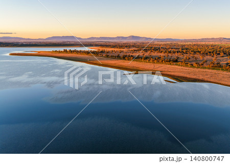 Aerial scene overlooking Lake Keepit and the surrounding rural landscape at dusk, capturing the tranquil reservoir beneath the soft evening light in NSW, Australia. Aerial scene overlooking Lake Keepit and the surrounding rural landscape at dusk, capturing the tranquil reservoir beneath the soft evening light in NSW, Australia. 140800747