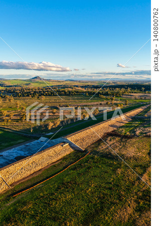 Aerial vertical view showcasing the Lake Keepit earth embankment and surrounding rural landscape, highlighting the scale of the reservoir and the engineering features of the dam in NSW, Australia. 140800762