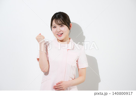 ピンクのナース服を着た笑顔で応援、ガッツポーズをする美容系の看護師、歯科衛生士、歯科助手等をイメージ 140800917