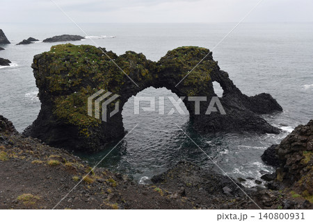 The iconic Gatklettur rock arch extending into the sea at Arnarstapi, Iceland The iconic Gatklettur rock arch extending into the sea at Arnarstapi, Iceland 140800931