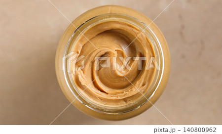 Open Jar of Peanut Butter on Warm Beige Background, Top View Open Jar of Peanut Butter on Warm Beige Background, Top View 140800962