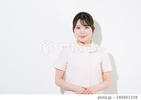 ピンクのナース服を着た笑顔で案内や歯科医院の受付のポーズをする美容系の看護師、歯科衛生士、歯科助手等 140801339