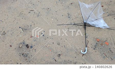 雨風で壊れて地面に放置された透明なビニール傘 雨風で壊れて地面に放置された透明なビニール傘 140802626