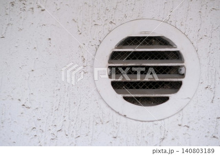 White round dirty and dusty air vent panel on wall of residential building. Ventilation and temperature regulation. Maintenance of household, interior or exterior air grille. Cleaning services 140803189