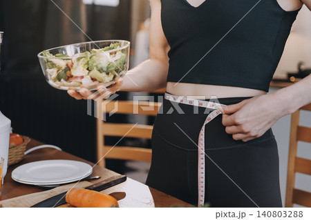 Woman preparing green smoothie in bright kitchen with fresh fruits and vegetables, healthy eating lifestyle moment in natural daylight Woman preparing green smoothie in bright kitchen with fresh fruits and vegetables, healthy eating lifestyle moment in natural daylight 140803288