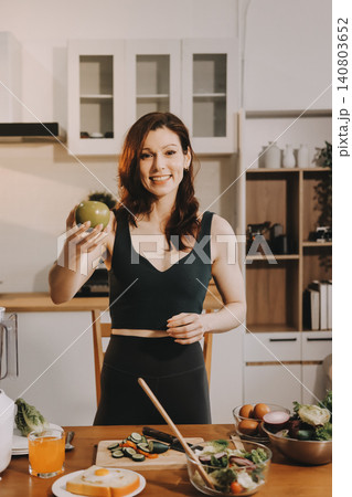 Woman preparing green smoothie in bright kitchen with fresh fruits and vegetables, healthy eating lifestyle moment in natural daylight Woman preparing green smoothie in bright kitchen with fresh fruits and vegetables, healthy eating lifestyle moment in natural daylight 140803652