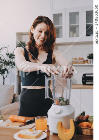 Woman preparing green smoothie in bright kitchen with fresh fruits and vegetables, healthy eating lifestyle moment in natural daylight Woman preparing green smoothie in bright kitchen with fresh fruits and vegetables, healthy eating lifestyle moment in natural daylight 140803660