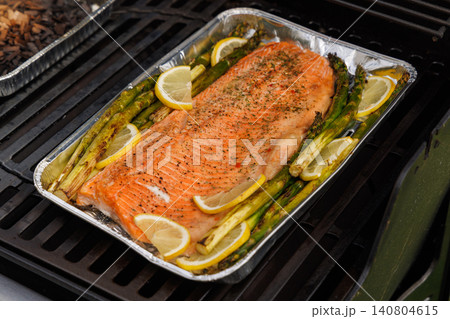 Grilled salmon fillets and asparagus sizzling on a barbecue grill Grilled salmon fillets and asparagus sizzling on a barbecue grill 140804615