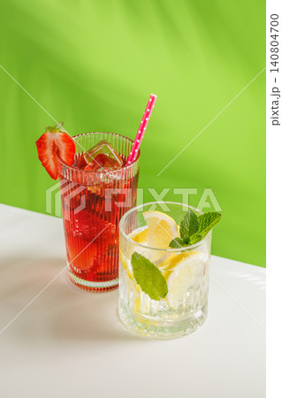 Healthy non alcoholic drinks with strawberry and lemon on green background Healthy non alcoholic drinks with strawberry and lemon on green background 140804700