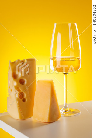 Glass of white wine with cheese on yellow background food pairing concept Glass of white wine with cheese on yellow background food pairing concept 140804852
