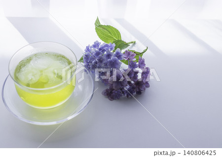 朝の光に包まれた紫陽花と冷たい緑茶のテーブルフォト 140806425