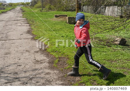 Cheerful girl runs along green grass near country road. Cheerful girl runs along green grass near country road. 140807469