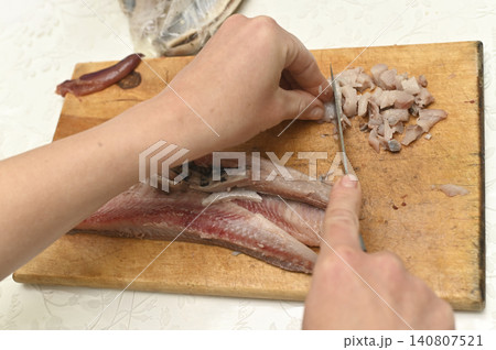 Top view of slicing herring on wooden board. Top view of slicing herring on wooden board. 140807521