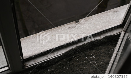 hail scattered on window sill and ground outside, hail scattered on window sill and ground outside, 140807555