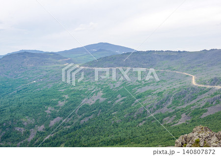 Mountain landscape in summer. Distant road through the mountains. 140807872