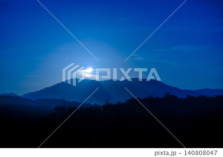 moonlight in the blue clear sky with a silhouette foreground of a forest and hill moonlight in the blue clear sky with a silhouette foreground of a forest and hill 140808047