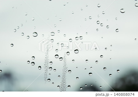 raindrops during raining in the rainy day outside window glass with a blurred background with water droplets flowing down the surface raindrops during raining in the rainy day outside window glass with a blurred background with water droplets flowing down the surface 140808074