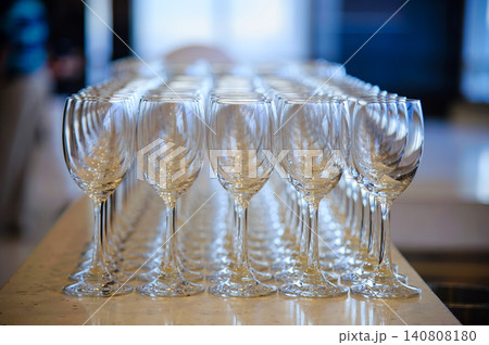 Many empty wine glasses line up waiting to pour some liquor for many invitation guests in the dinner reception celebration party in a lounge in the hotel. 140808180