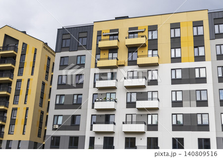 Modern residential building facade with geometric balconies, brick accent walls, and contemporary apartment block design. Modern residential building facade with geometric balconies, brick accent walls, and contemporary apartment block design. 140809516