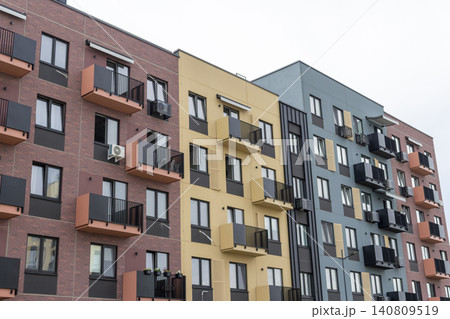 Modern residential building facade with geometric balconies, brick accent walls, and contemporary apartment block design. Modern residential building facade with geometric balconies, brick accent walls, and contemporary apartment block design. 140809519