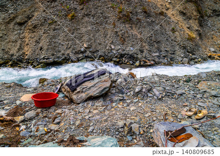 Washing Clothes by a Rocky River in Kyrgyzstan 140809685