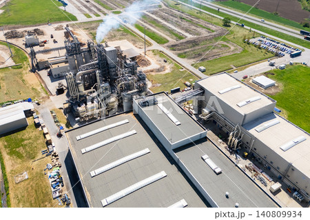 Aerial shot of a manufacturing facility with smoking chimney during production. Aerial shot of a manufacturing facility with smoking chimney during production. 140809934
