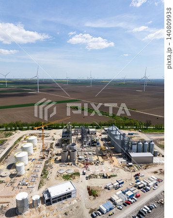 Construction of a modern agricultural grain terminal with wind turbines on the horizon. Construction of a modern agricultural grain terminal with wind turbines on the horizon. 140809938