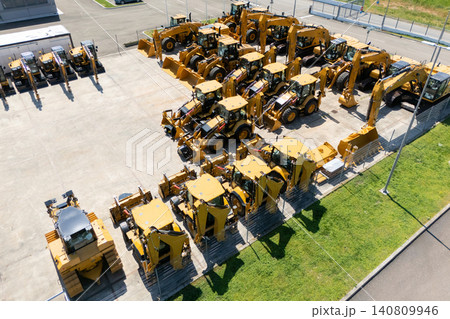 New hydraulic excavators and tractors parked at a construction machinery dealership New hydraulic excavators and tractors parked at a construction machinery dealership 140809946
