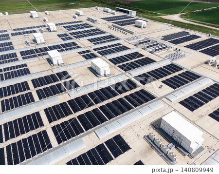 Aerial view of a modern factory with solar panels and energy storages on the roof. Aerial view of a modern factory with solar panels and energy storages on the roof. 140809949