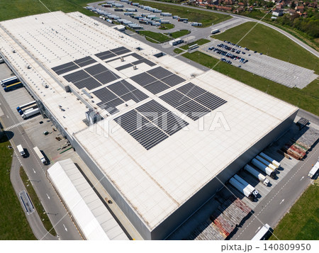 Aerial view of a modern logistics center with solar panels on the roof. 140809950