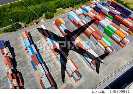 Aerial view of an airplane shadow cast over a container terminal Aerial view of an airplane shadow cast over a container terminal 140809951