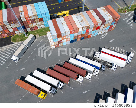Aerial view of a logistics hub with multicolored shipping containers and trucks 140809953