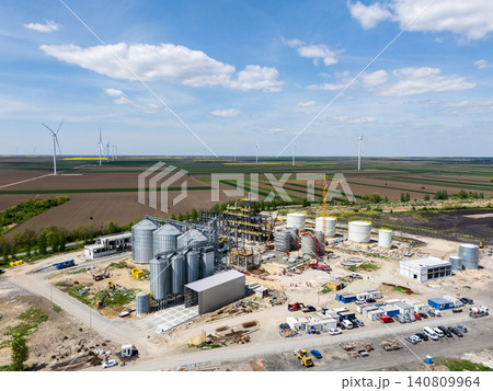 Construction of a modern agricultural grain terminal with wind turbines on the horizon. Construction of a modern agricultural grain terminal with wind turbines on the horizon. 140809964