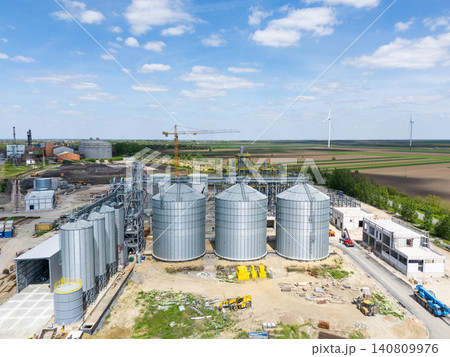 Construction of a modern agricultural grain terminal with wind turbines on the horizon. Construction of a modern agricultural grain terminal with wind turbines on the horizon. 140809976