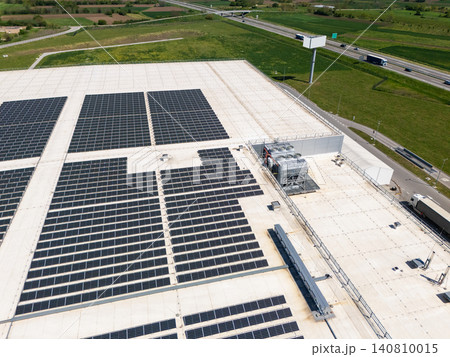 Aerial view of a modern logistics center with solar panels on the roof. 140810015