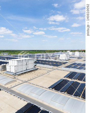Aerial view of a modern factory with solar panels and energy storages on the roof. Aerial view of a modern factory with solar panels and energy storages on the roof. 140810092