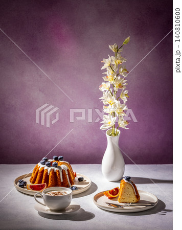 Delicious gugelhupf cake with cappuccino and orchid flower on purple background Delicious gugelhupf cake with cappuccino and orchid flower on purple background 140810600