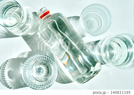 Glass bottle with water and empty glasses Glass bottle with water and empty glasses 140811195