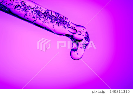 Glass pipette dispensing purple hyaluronic acid serum drop Glass pipette dispensing purple hyaluronic acid serum drop 140811310