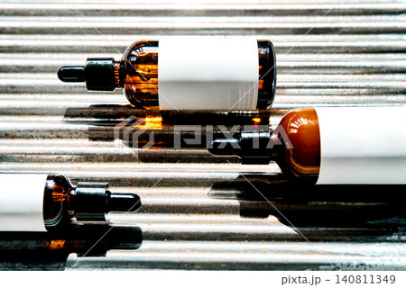 Amber glass droppers with labels on corrugated metal Amber glass droppers with labels on corrugated metal 140811349