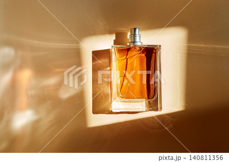 Perfume bottle capturing sunlight with amber liquid and elegant reflections Perfume bottle capturing sunlight with amber liquid and elegant reflections 140811356