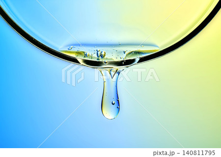 Peptide based serum with bubbles dropping against a vibrant blue and yellow gradient background Peptide based serum with bubbles dropping against a vibrant blue and yellow gradient background 140811795