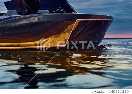 Incredible reflection on the glossy side of a modern motorboat at sunset, the Gulf of Finland, magic reflections on water surface Incredible reflection on the glossy side of a modern motorboat at sunset, the Gulf of Finland, magic reflections on water surface 140811830