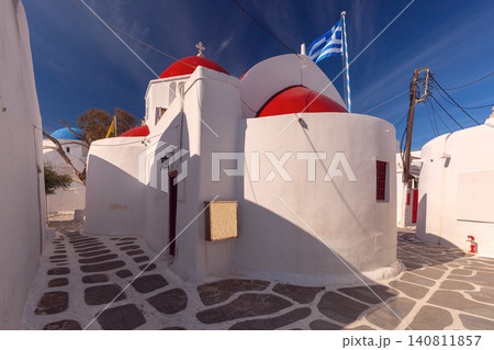 White church with bell tower in Mykonos town under clear blue sky, Greece 140811857