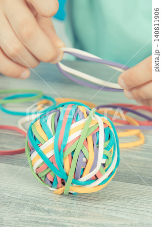Preschooler hands with ball of rubber bands or erasers 140811906