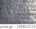 Weathered aluminum surface with dents and scratches outdoors 140812118