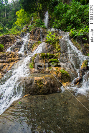 Beautiful silk effect waterfall flowing down mossy rock cliffs at Goa Tetes Lumajang Indonesia Beautiful silk effect waterfall flowing down mossy rock cliffs at Goa Tetes Lumajang Indonesia 140812379