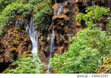 Beautiful silk effect waterfall flowing down mossy rock cliffs at Goa Tetes Lumajang Indonesia Beautiful silk effect waterfall flowing down mossy rock cliffs at Goa Tetes Lumajang Indonesia 140812397