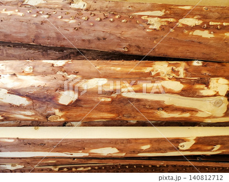 horizontal wooden boards with unedged bark lie on top of each other horizontal wooden boards with unedged bark lie on top of each other 140812712
